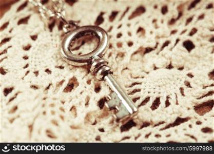 Vintage key on the white aged lace. The Vintage key