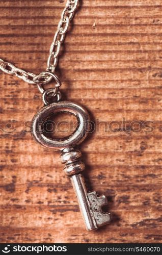 Vintage key on the wooden shabby background