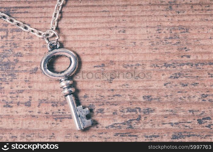Vintage key on the wooden shabby background. The Vintage key