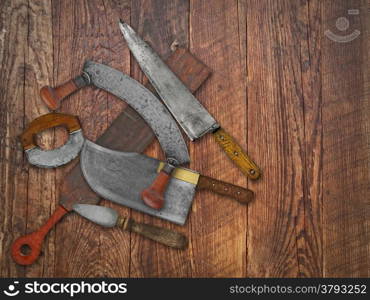 vintage kitchen knives and sharpening tools collage over old wooden table, space for your text