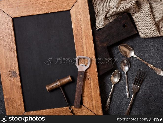 Vintage kitchen wooden utensils with chalk menu board on stone table background. Top view.