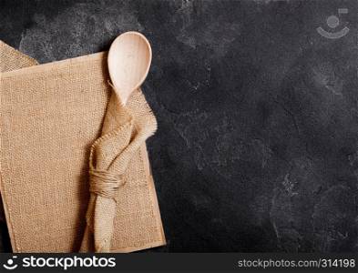 Vintage kitchen wooden utensils with linen board on stone table background. Top view.