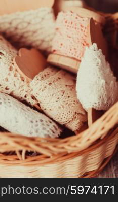 Vintage lace on the wooden bobbin in a basket. The Vintage lace