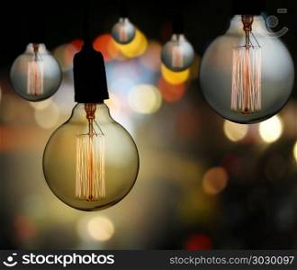 Vintage lamp or Modern Light bulb hang on ceiling in bokeh backg. Vintage lamp or Modern Light bulb hang on ceiling in bokeh background,concept of interior and design in your work.