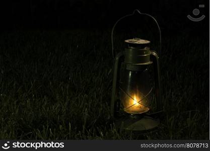 Vintage lantern in the night. Green garden