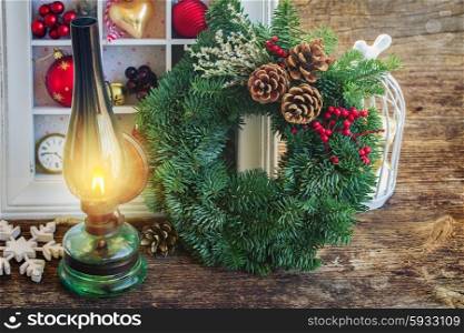 vintage lantern with christmas wreath. vintage burning lantern with christmas decorations and green wreath