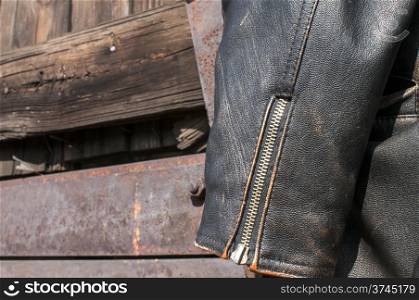 Vintage leather male jacket sleeve on old railway wagon background