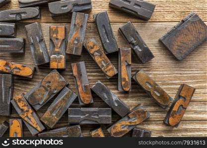 vintage letterpress wood type printing blocks stained by inks placed randomly on a wooden table