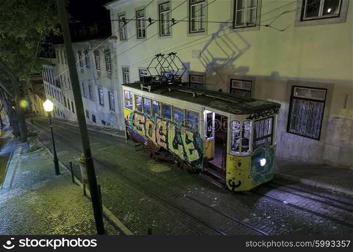 Vintage Lisbon lift (elevator) painted with graffiti on city street at night, Portugal&#xA;