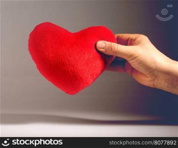 Vintage look red plush heart. Hand holding red heart