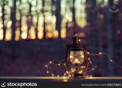 Vintage magic lantern with lights at night forest