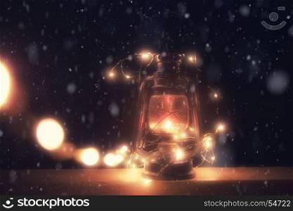 Vintage magic lantern with lights at snowy winter night