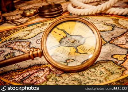 Vintage magnifying glass lies on the ancient map of the North Pole (also Hyperborea). Arctic continent on the Gerardus Mercator map of 1595.