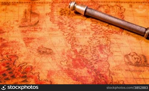Vintage magnifying glass lying on ancient world map in 1565.