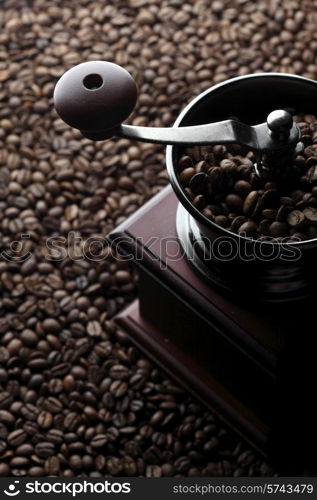 Vintage manual coffee grinder on roasted coffee beans