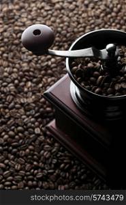 Vintage manual coffee grinder on roasted coffee beans