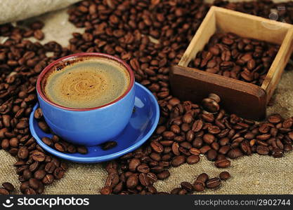 Vintage manual coffee grinder with coffee beans and cup