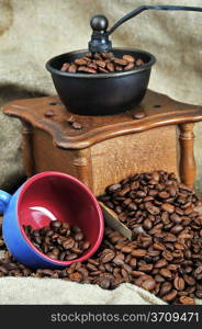 Vintage manual coffee grinder with coffee beans and cup