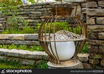 vintage metal garden lantern on green lawn