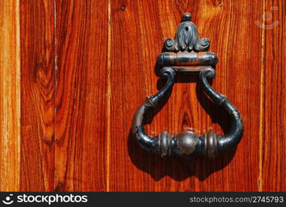 vintage metal handle on a bright wooden door
