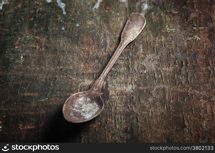 Vintage metal spoon on wooden background