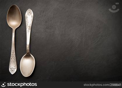 Vintage metal spoons on dark background