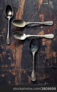 Vintage metal spoons on wooden background