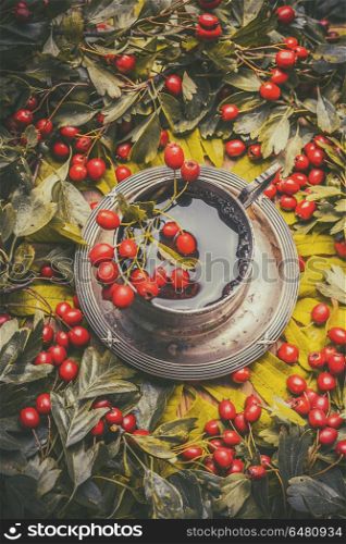 Vintage mug with herbal autumn tea with red berries, top view