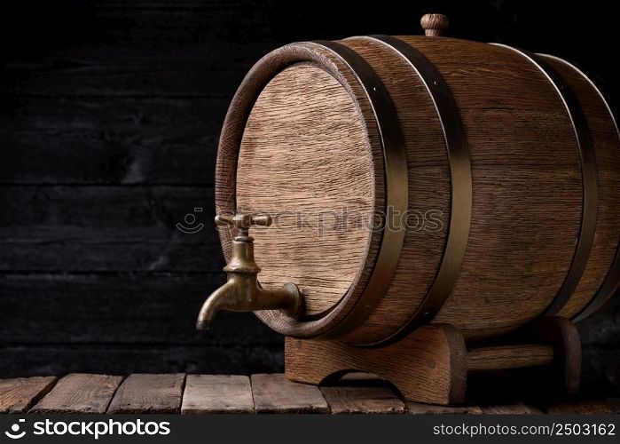 Vintage oak barrel on rack on old wooden table still life