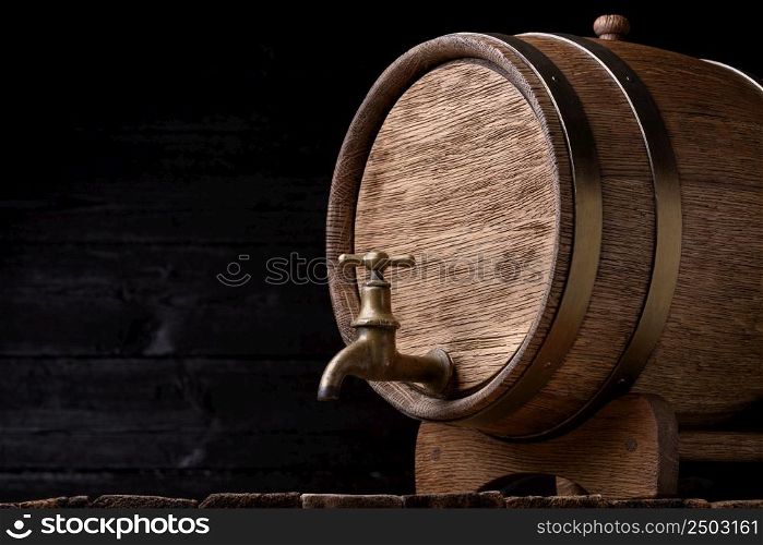 Vintage oak barrel on rack on old wooden table still life with copy space