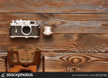 Vintage old 35mm camera and lens on wooden background