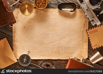 Vintage old 35mm camera on wooden background with old blank paper sheet