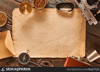 Vintage old 35mm camera on wooden background with old blank paper sheet
