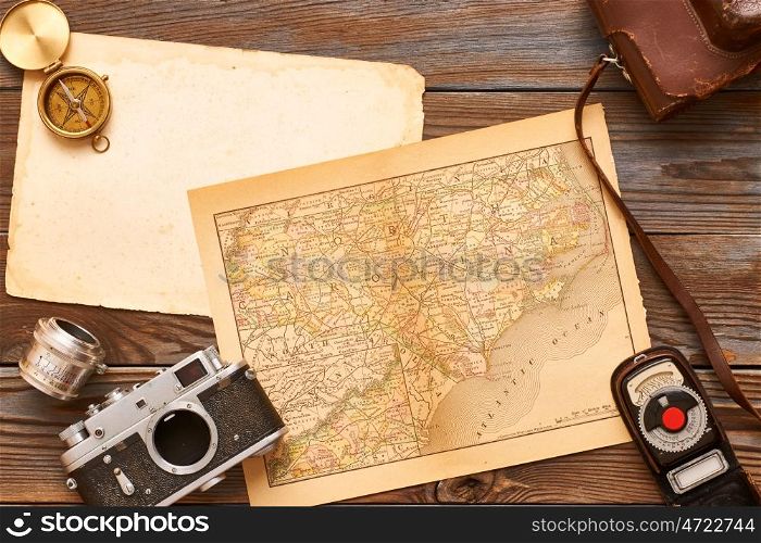 Vintage old 35mm cameras, lenses and light meter on wooden background with antique XIX century map