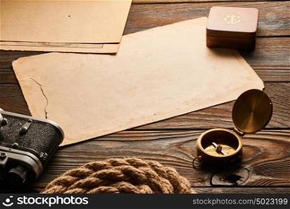 Vintage old 35mm rangefinder camera, old compass on wooden background with antique XIX century map