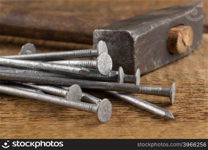 Vintage old hammer with rusty nails on wood table background
