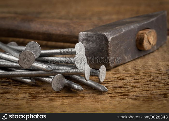 Vintage old hammer with rusty nails on wood table background