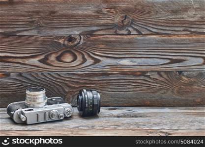 Vintage old retro 35mm rangefinder camera and lens . Vintage old retro 35mm rangefinder camera and lens on wooden background with copy space