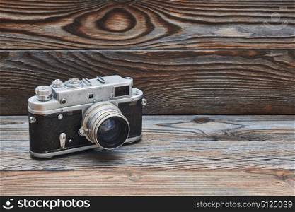 Vintage old retro 35mm rangefinder camera on wooden background with copy space