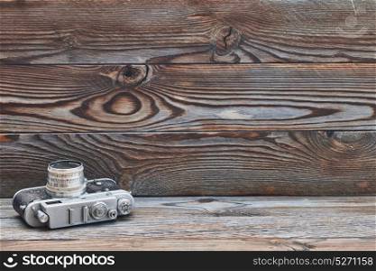 Vintage old retro 35mm rangefinder camera on wooden background with copy space