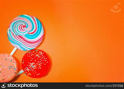 Vintage orange background with three varicolored candy. Space for copy. Vintage Orange Background With Colored Candy
