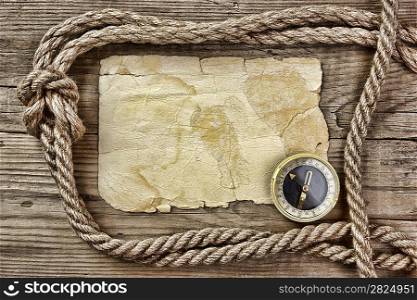 Vintage paper with compass and rope on old wooden boards