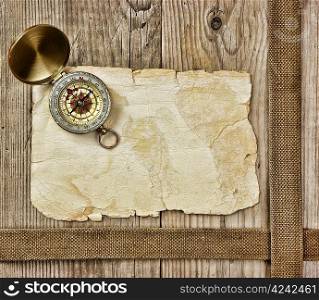 Vintage paper with compass on old wooden boards