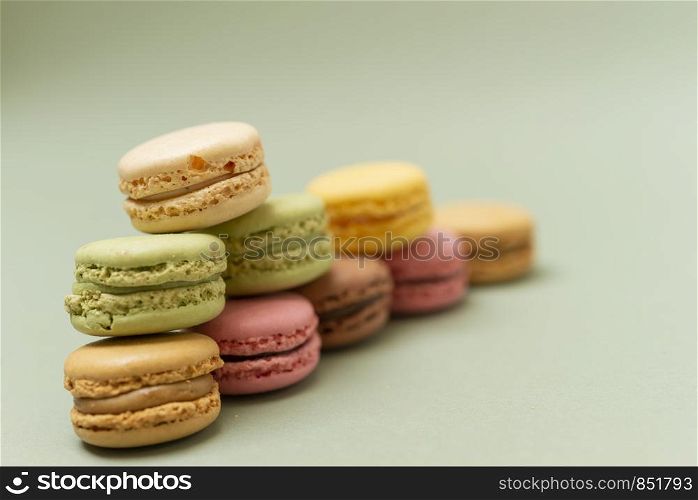Vintage pastel colored French macaroons or macarons on green background