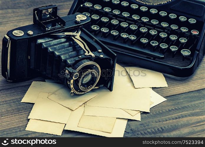 Vintage photo camera and antique typewriter. Retro style toned picture