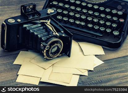Vintage photo camera and antique typewriter. Retro style toned picture