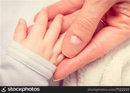 Vintage photo, Mother holding hand of her newborn baby boy, concept of babies care. Vintage photo, Hand of newborn baby in hand of mother