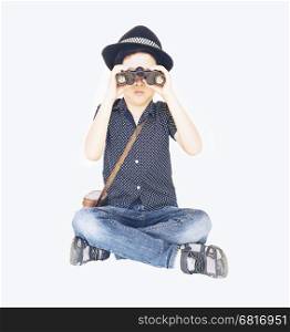 Vintage photo of 7 years old Asian traveler boy is sitting and using binoculars