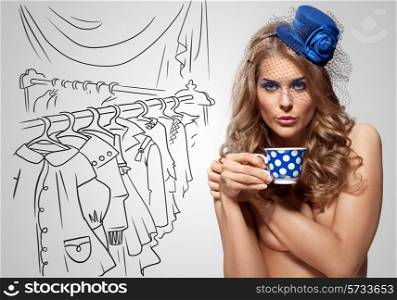 Vintage photo of a beautiful nude girl in a retro hat drinking tea on sketchy background of a dressing room.