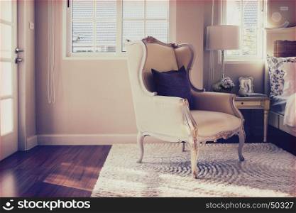 vintage photo of classic chair with brown pillow on carpet in luxury bedroom interior